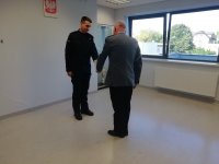 Policjant odbiera akt ślubowania od Komendanta Powiatowego Policji w Poddębicach, insp. Krzysztofa Kotkowskiego.