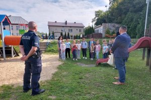 Na zdjęciu policjant oraz wójt gminy Dalików i grupa dzieci.