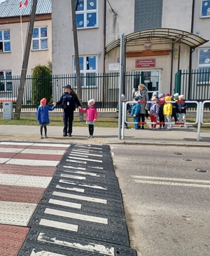dzieci przechodzą przez pasy z policjantką
