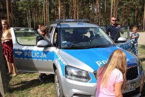 policjant pokazuje radiowóz