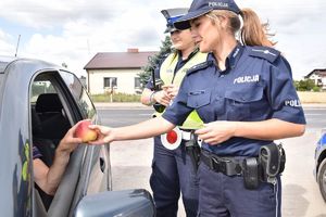 policjanci wręczają jabłko