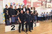 Zwycięzkie drużyny miejsce 1, 2 i 3  stoją na podium, obok stoi Komendant Wojewódzki Policji w Łodzi, pamiątkowe zdjęcie