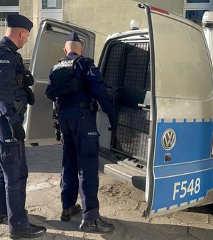 Zatrzymany wsiada do radiowozu.