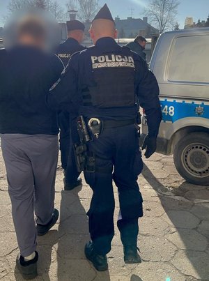 Policjanci prowadzą zatrzymanego.