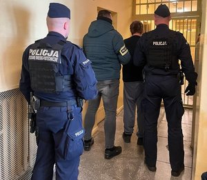 Policjanci prowadzą zatrzymanego.