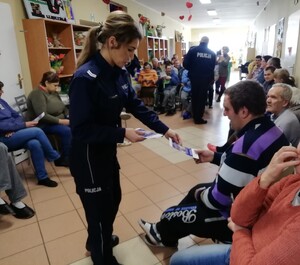 policjantka rozdaje pensjonariuszom ulotki