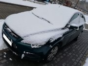 Na zdjęciu widać zaśnieżony samochód osobowy.