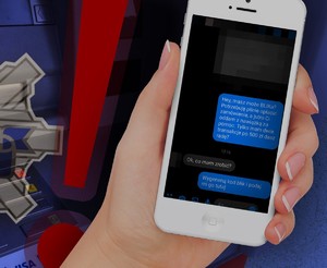 telefon w dłoni, na ekranie tekst dotyczący próby wyłudzenia pieniędzy metodą blick