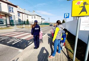 policjantka przeprowadza dziecko przez pasy