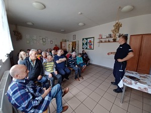 policjant omawia z pensjonariuszami podstawowe zasady bezpieczeństwa
