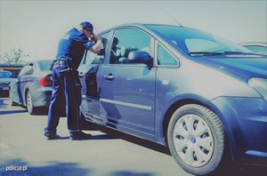 policjant zagląda do samochodu przez szybę