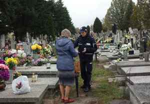 policjantka na cmentarzu rozmawia z seniorem