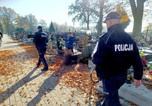 policjanci rozdają odblaski na cmentarzu