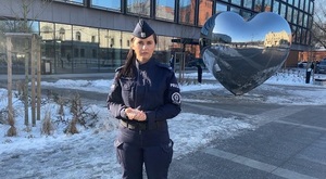 policjantka na tle  figury serca w centrum Łodzi