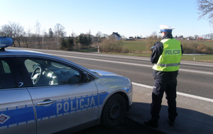 Policjanci podczas kontroli drogowej i pomiaru prędkości.