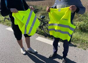 Policjant rozdający elementy odblaskowe.