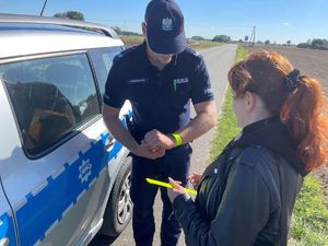 Policjant rozdający elementy odblaskowe.