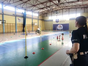Policjantka obserwująca dzieci pokonujące tor przeszkód.