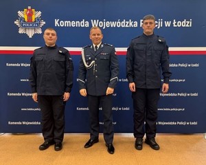 Komendant, po jego bokach nowo przyjęci policjanci.