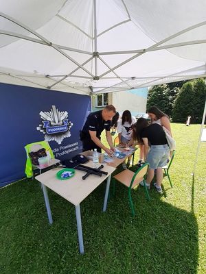 Namiot policyjny i dzieci zgromadzone wokół niego.