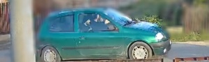 Zielone auto, w pojeździe znajduje się mężczyzna.