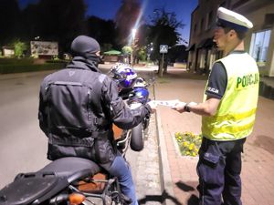 Policjant wręczający ulotkę.