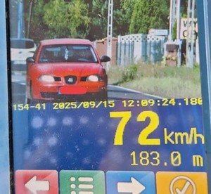 Zdjęcie z urządzenia do pomiaru prędkości przedstawiające czerwony pojazd.