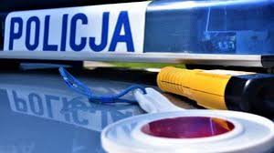 Napis Policja na dachu radiowozu, obok tarcza i urządzenie do badania stanu trzeźwości.