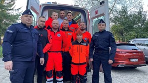 Policjanci i Zespół Ratownictwa Medycznego przy karetce - wspólne zdjęcie.