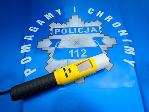 Urządzenie do pomiaru stanu trzeźwości, w tle napis Pomagamy i Chronimy.