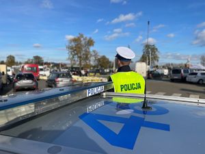 Policjant, w tle cmentarz.