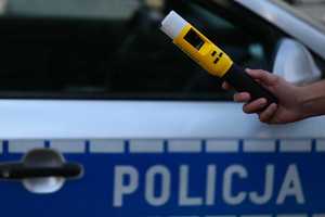 Urządzenie do pomiaru stanu trzeźwości, w tle radiowóz.