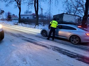 Policjant przy pojeździe sprawdzający trzeźwość kierowców.