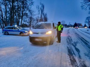Policjant przy pojeździe sprawdzający trzeźwość kierowców.