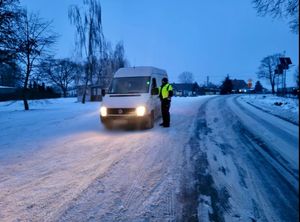 Policjant przy pojeździe sprawdzający trzeźwość kierowców.