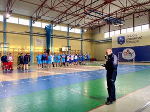 Otwarcie Turnieju, Komendant stoi przed zgromadzonymi drużynami, w ręku trzyma mikrofon.