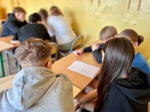 Uczniowie na hali sportowej pokonują tor przeszkód.