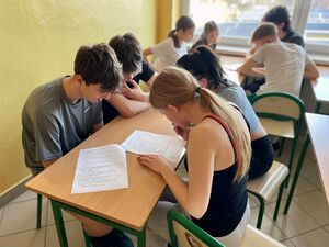 Uczniowie na hali sportowej pokonują tor przeszkód.