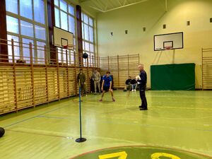 Uczniowie na hali sportowej pokonują tor przeszkód.