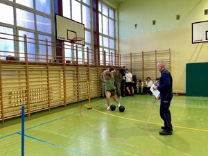 Uczniowie na hali sportowej pokonują tor przeszkód.
