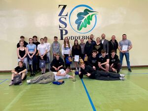 Uczniowie na hali sportowej pokonują tor przeszkód.