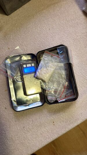 Waga, leżące na niej woreczki foliowe z zawartością białej substancji.