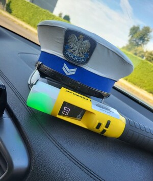 Policyjna czapka, obok urządzenie do badania stanu trzeźwości.