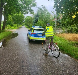 Policjanci i osoby w kamizelkach odblaskowych.