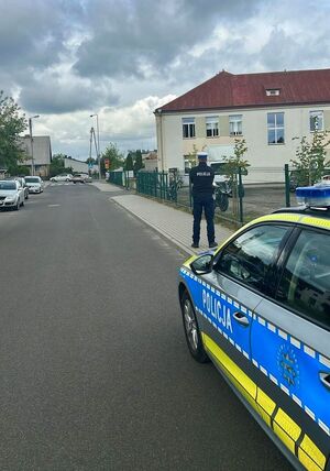Radiowozy stojące przed szkołą.