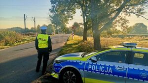Policjanci, w tle przejazd kolejowy.