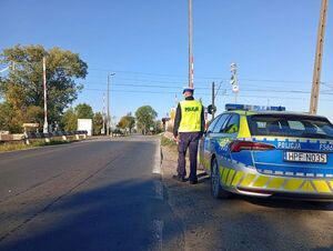 Policjanci, w tle przejazd kolejowy.