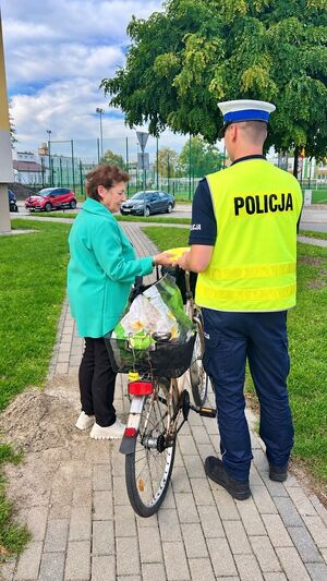 Policjanci rozdający kamizelki odblaskowe.