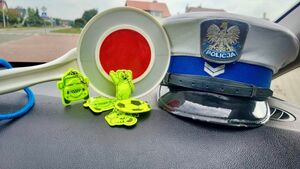 Policjanci rozdający kamizelki odblaskowe.