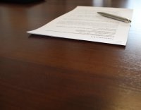 kartka z porozumieniem leży na stole, obok długopis